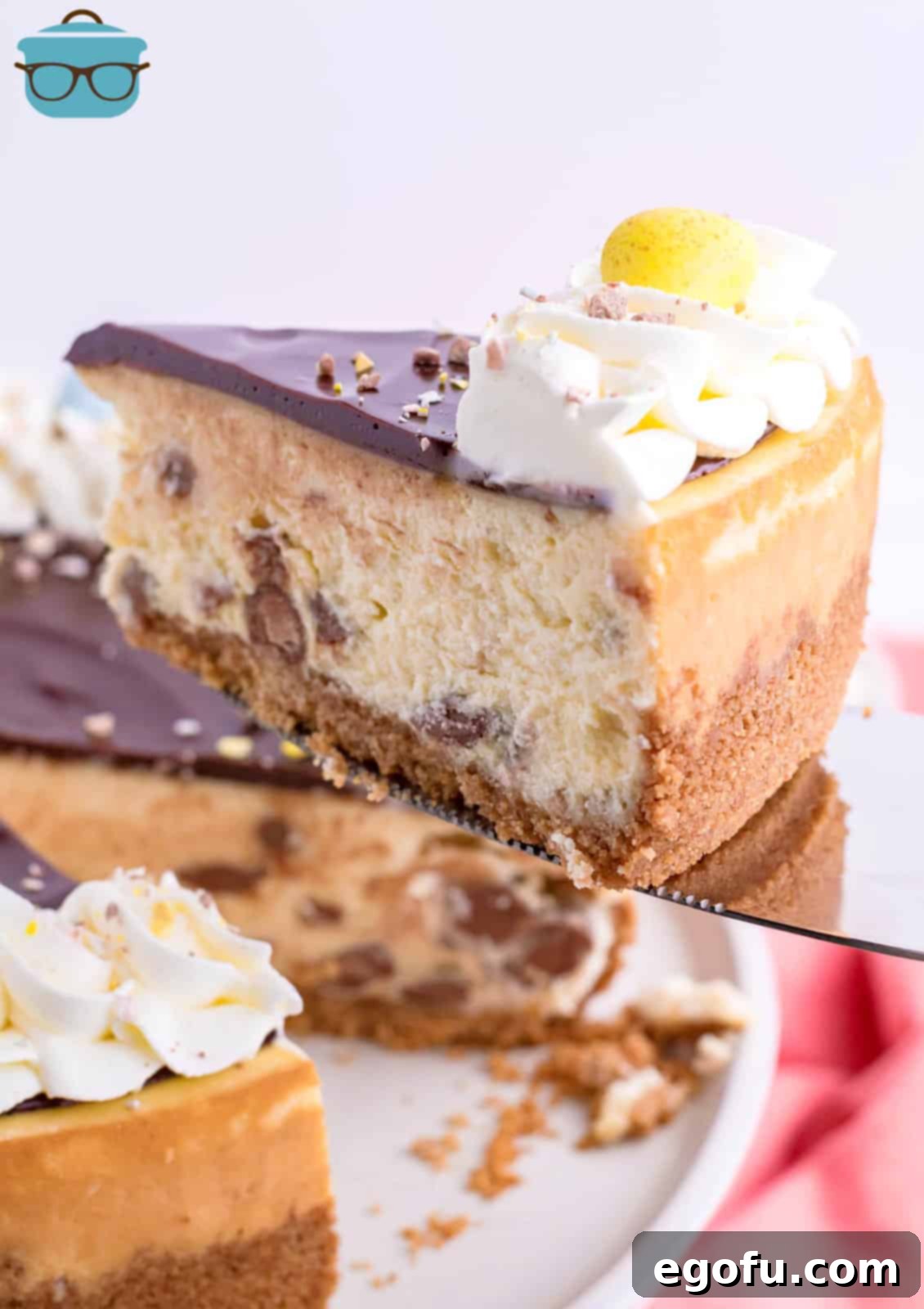 A serving utensil holding a slice of Cadbury Mini Egg Cheesecake.