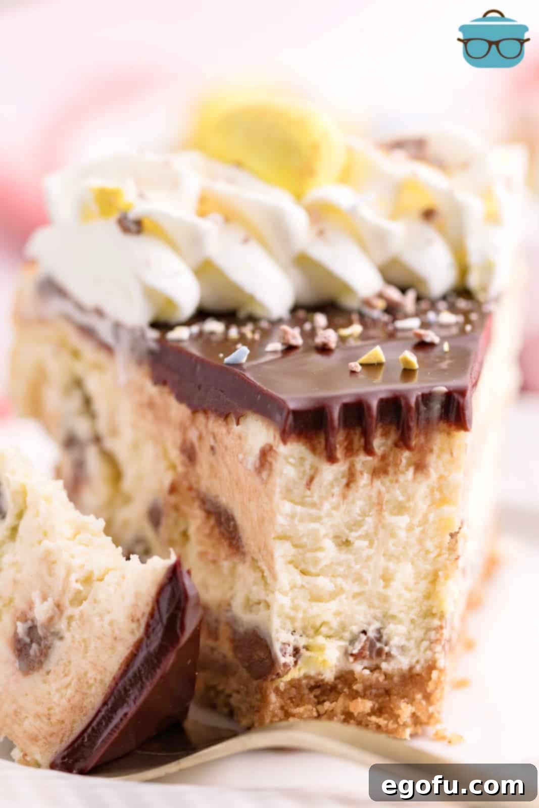 A slice of Mini Egg Cheesecake with a bite taken out.