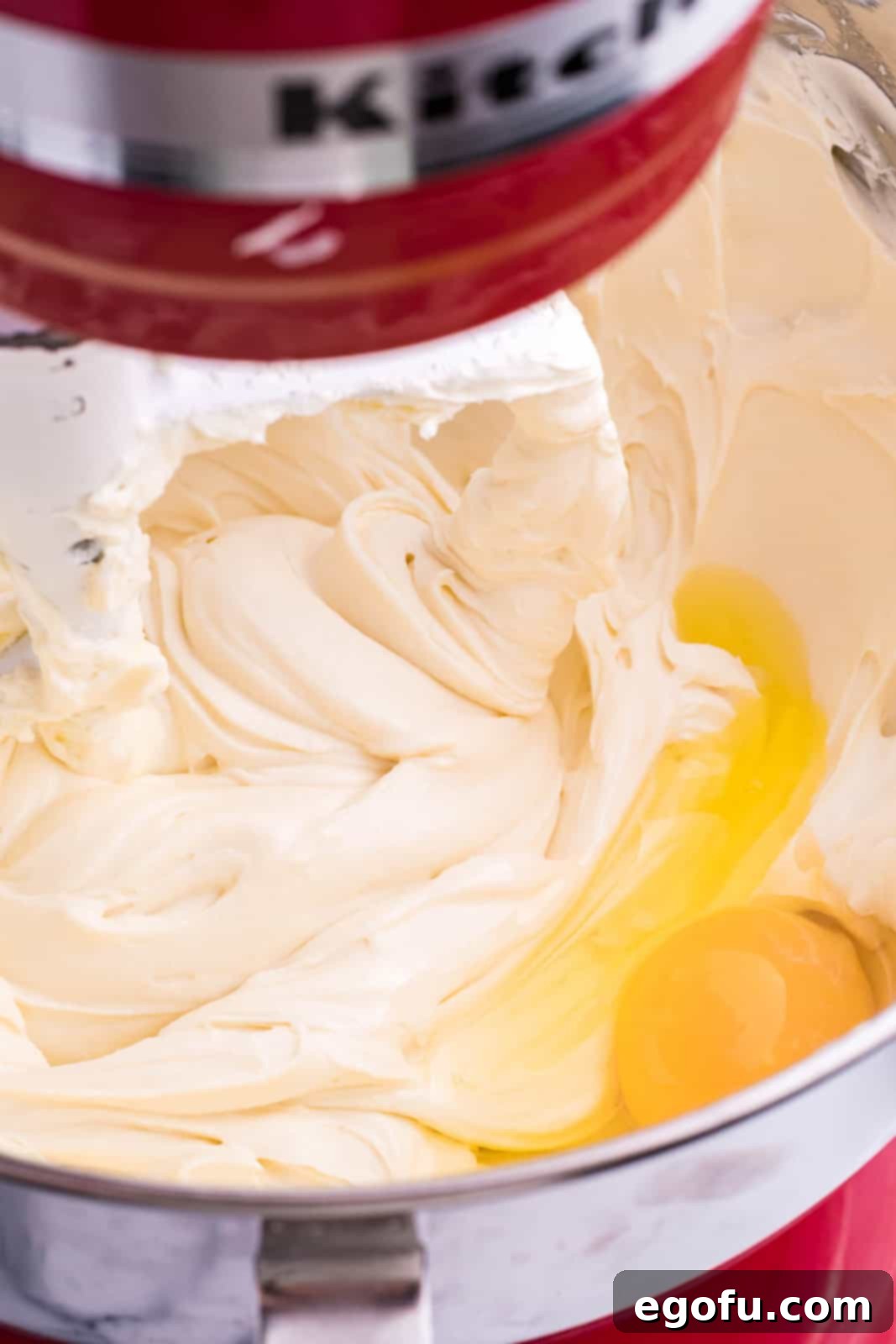 A cream cheese mixture with eggs in a mixing bowl.