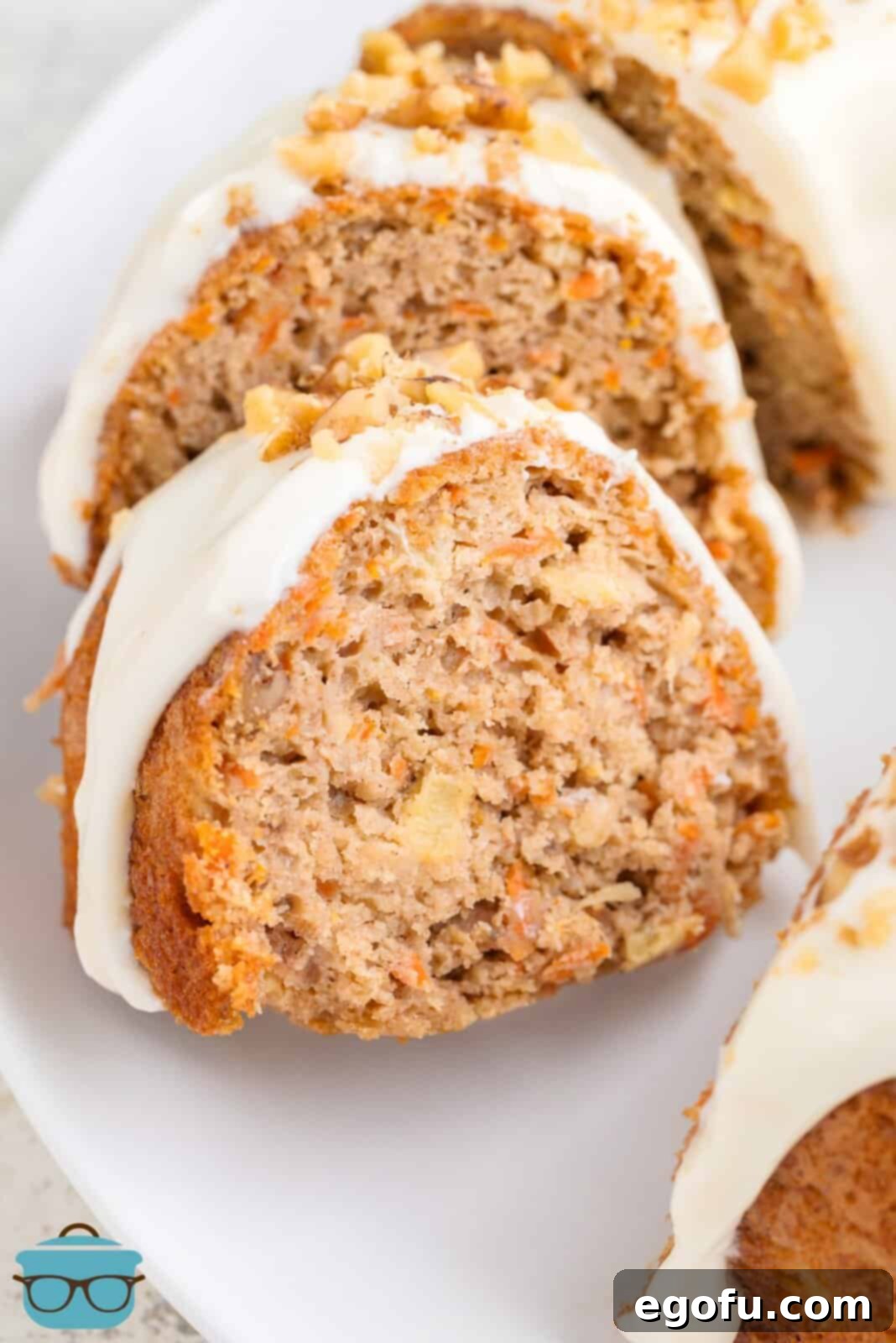 A few slices of Carrot Bundt Cake with glaze and chopped nuts on a serving plate.