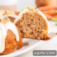 A slice of Carrot Bundt Cake being removed from the serving plate.