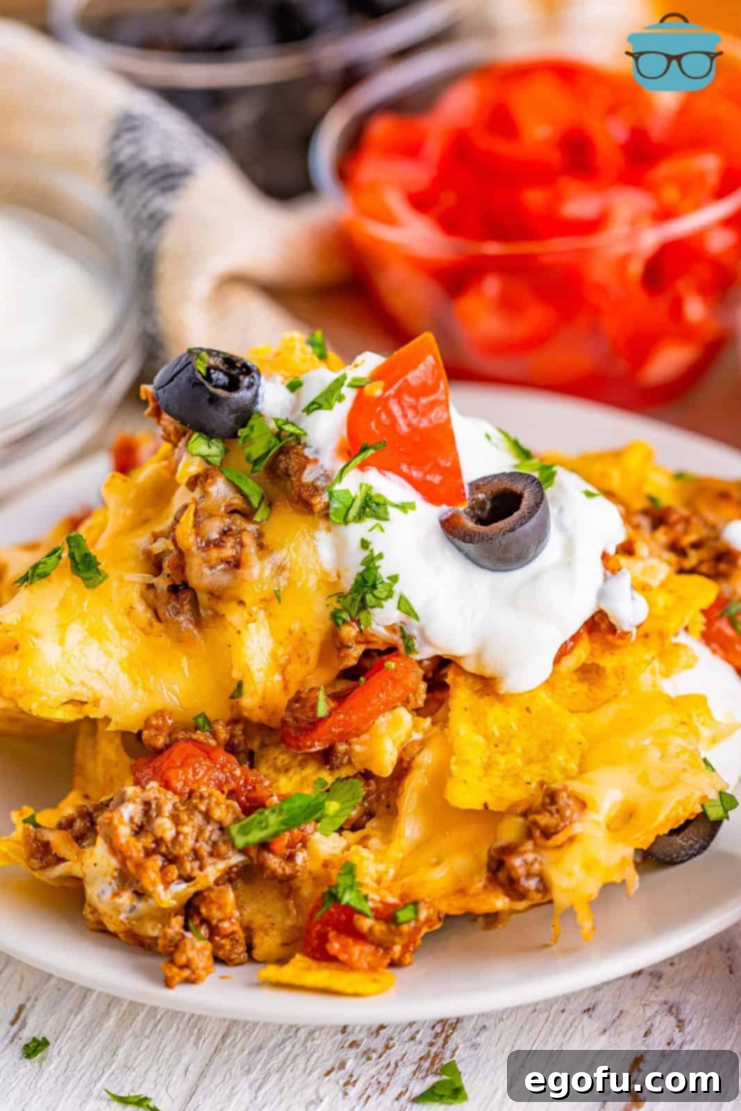 Close up view of a generous plate of sheet pan nachos, highlighting the various textures and toppings.