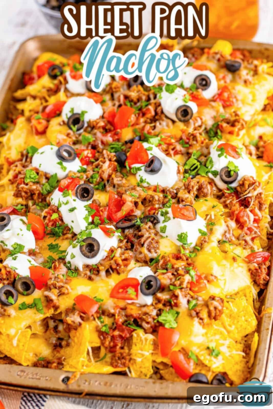 A vibrant sheet pan overflowing with perfectly baked, loaded nachos.