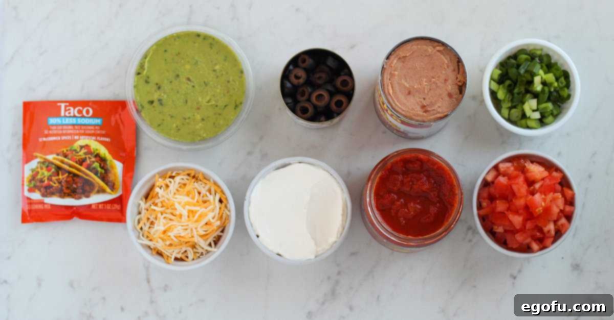 refried beans, taco seasoning, guacamole, sour cream, salsa, Colby Jack cheese, diced tomatoes, green onions and sliced olives. 