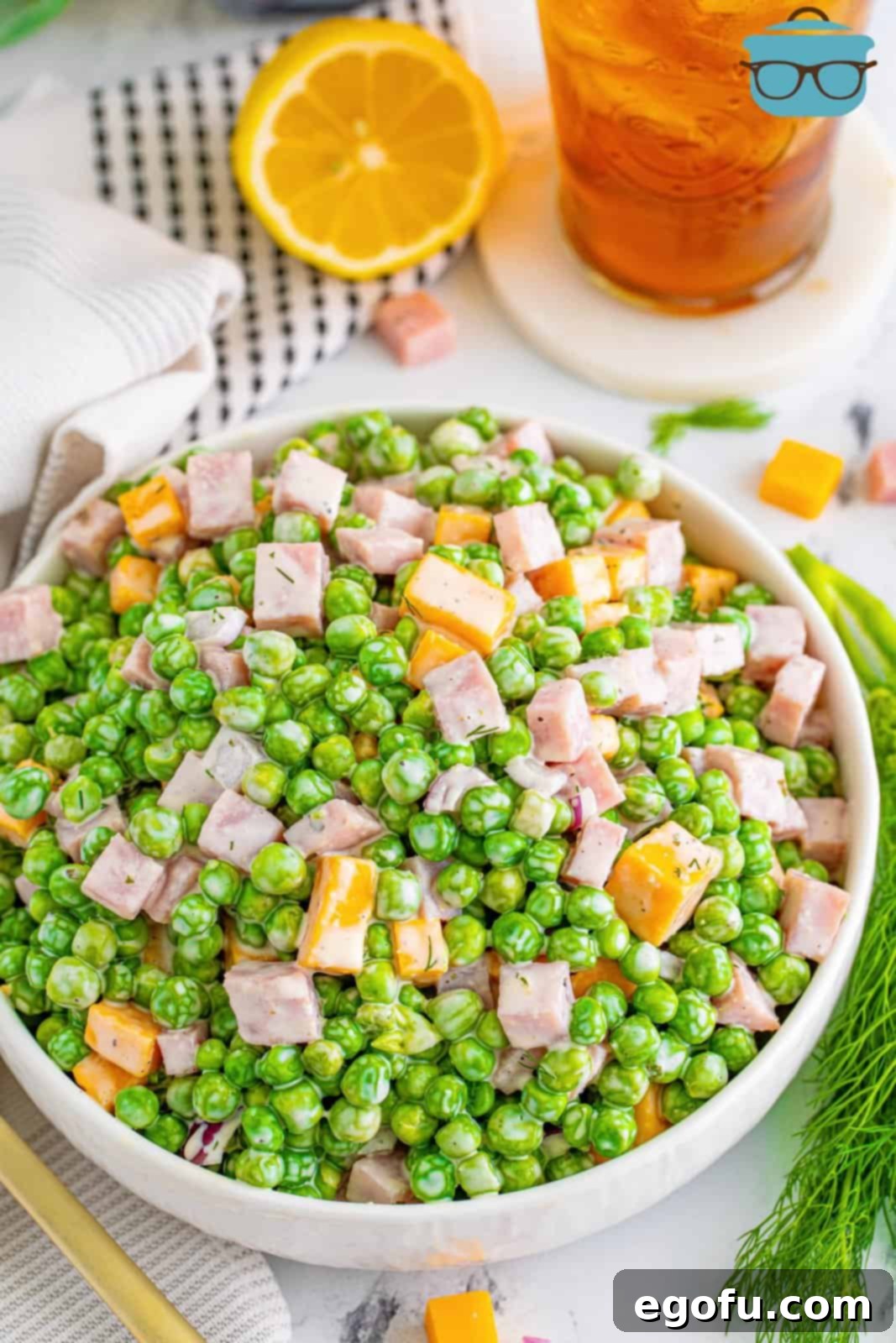 Creamy Garden Pea Salad 8 A bowl of pea salad with ham.
