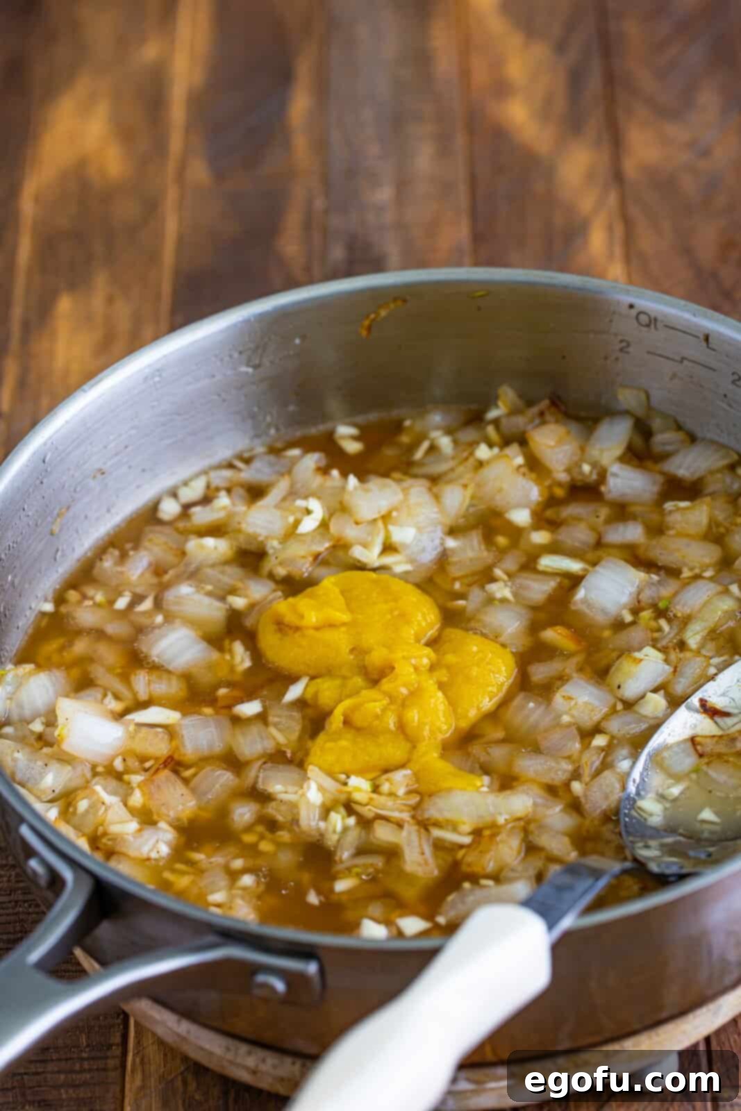 A saucepan with onions, garlic, and Better than Bouillon.