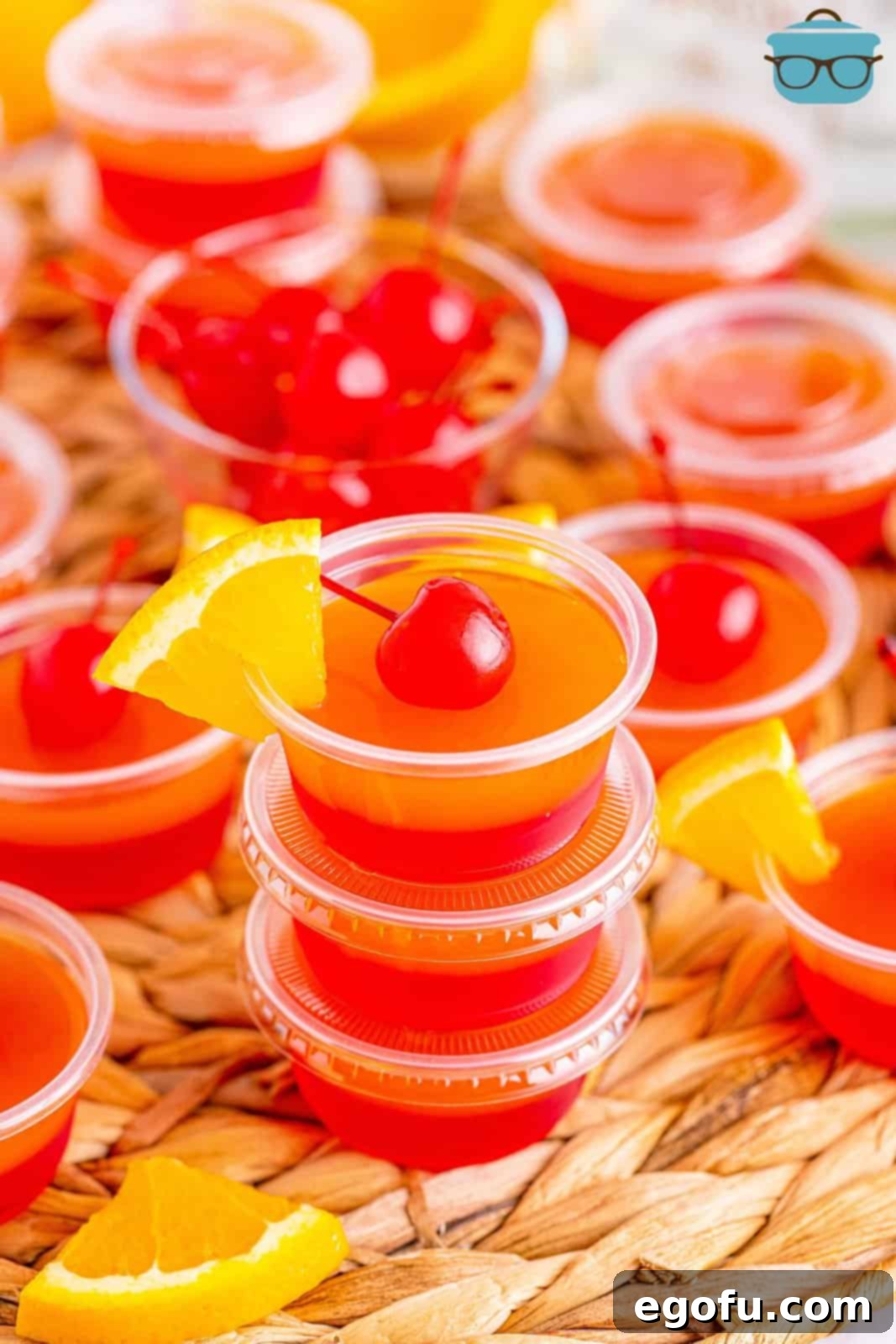 Agave Aurora Shots 2 A pile of Tequila Sunrise Jello Shots with garnishes on a few.