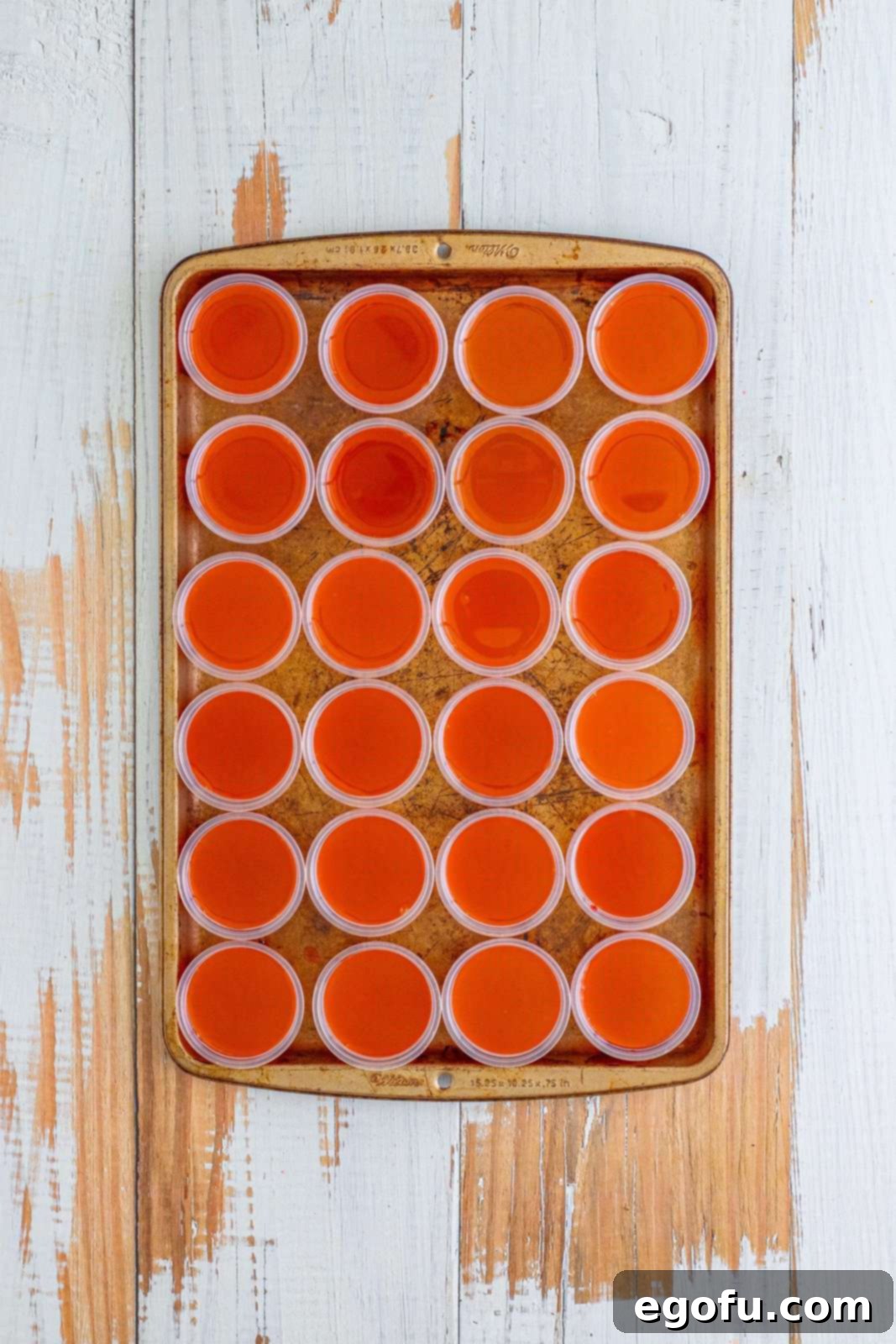 Agave Aurora Shots 8 Looking down on cups of layered orange and cherry jello shots in cups.