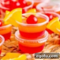 Agave Aurora Shots 10 Two Tequila Sunrise Jell-O Shots with a garnish on the top one.