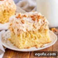 A cake with a slice of Butter Pecan Poke Cake.