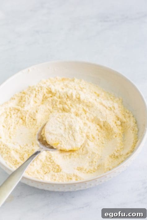 Down Home Fried Squash 15 Coating a piece of squash in a flour and cornmeal coating.