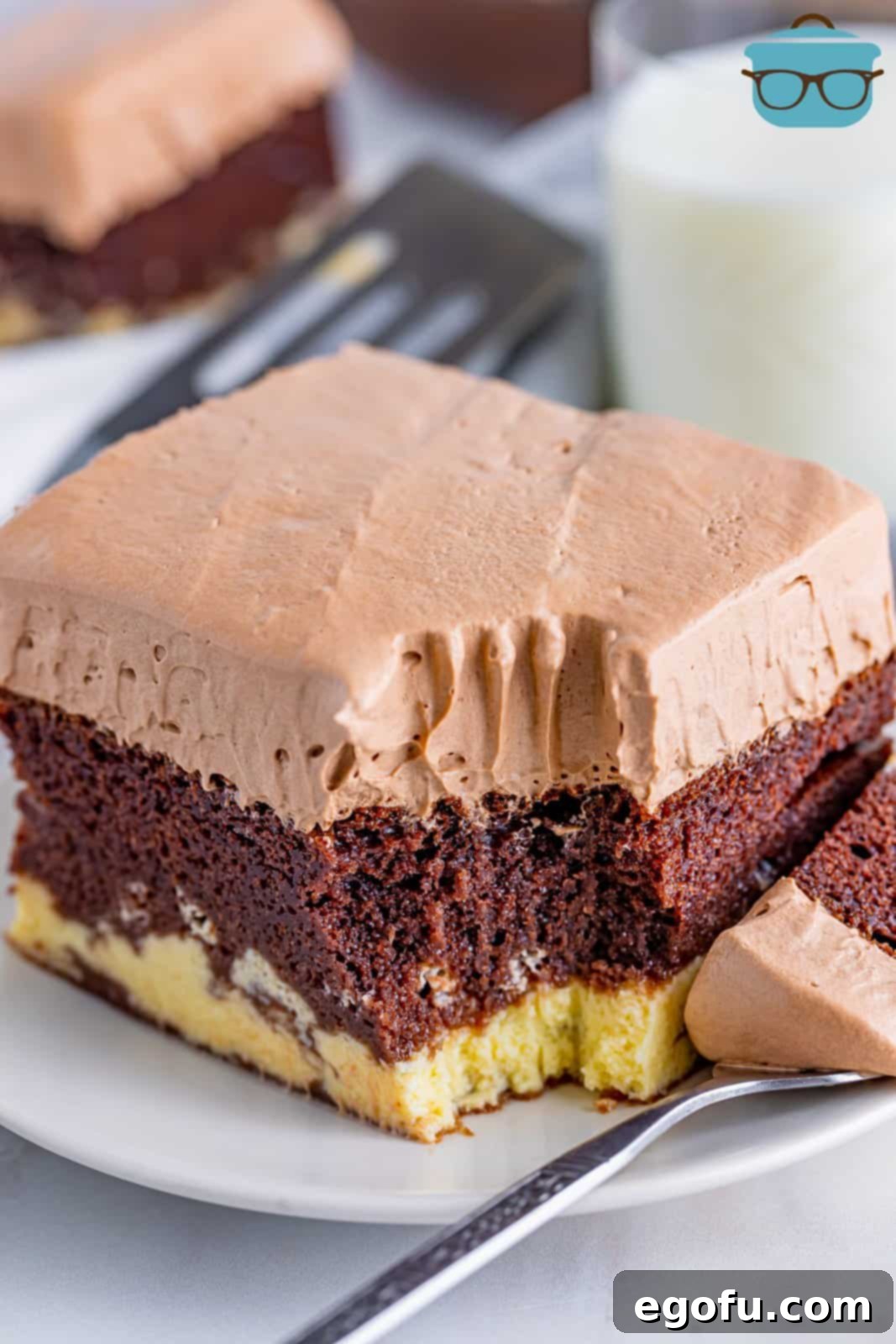 Amore Italian Dream Cake 2 A perfectly portioned slice of Italian Love Cake showcasing its distinct chocolate cake, ricotta, and pudding layers, with a small bite taken out, inviting a closer look at its delightful texture.