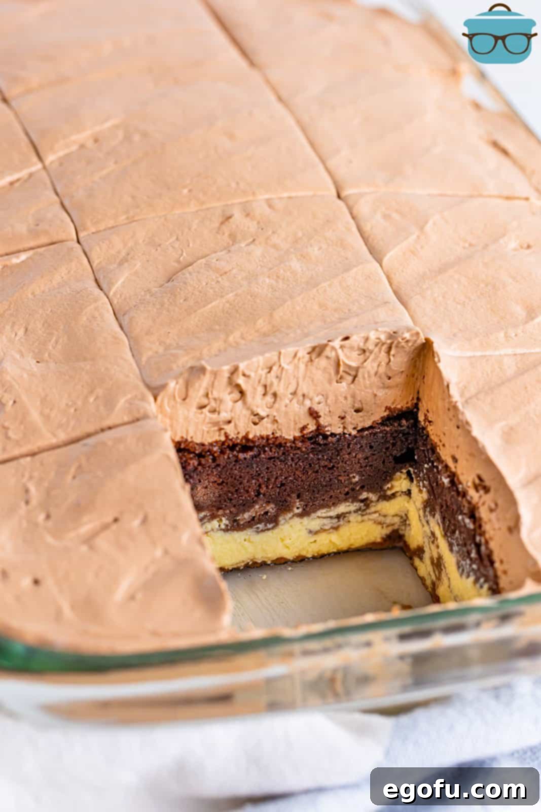 Amore Italian Dream Cake 8 A tantalizing close-up of a pan of Italian Love Cake, with one piece already removed, revealing the decadent layers and inviting guests to indulge in this delightful dessert.