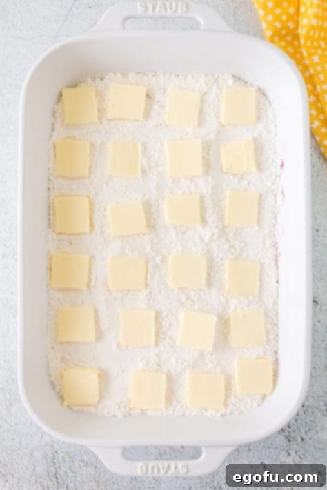 slices of butter placed on top of cake mix.