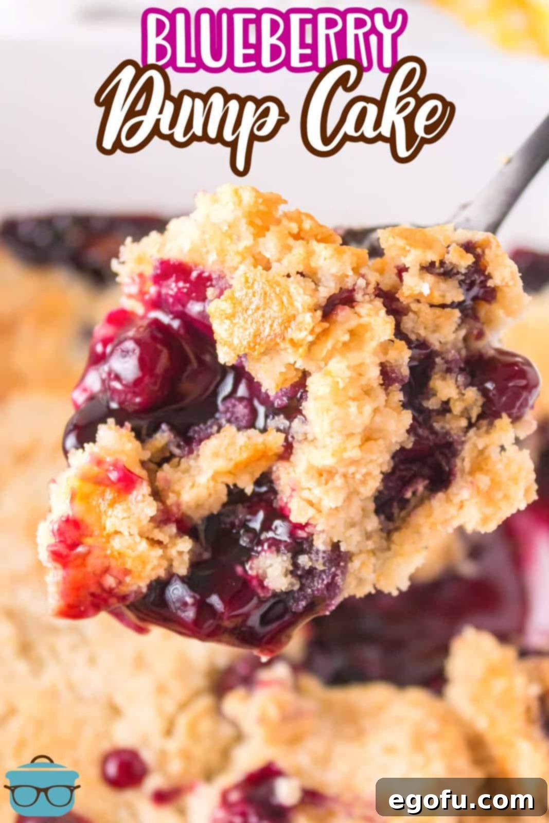 A serving utensil holding a bite of Blueberry Dump Cake.