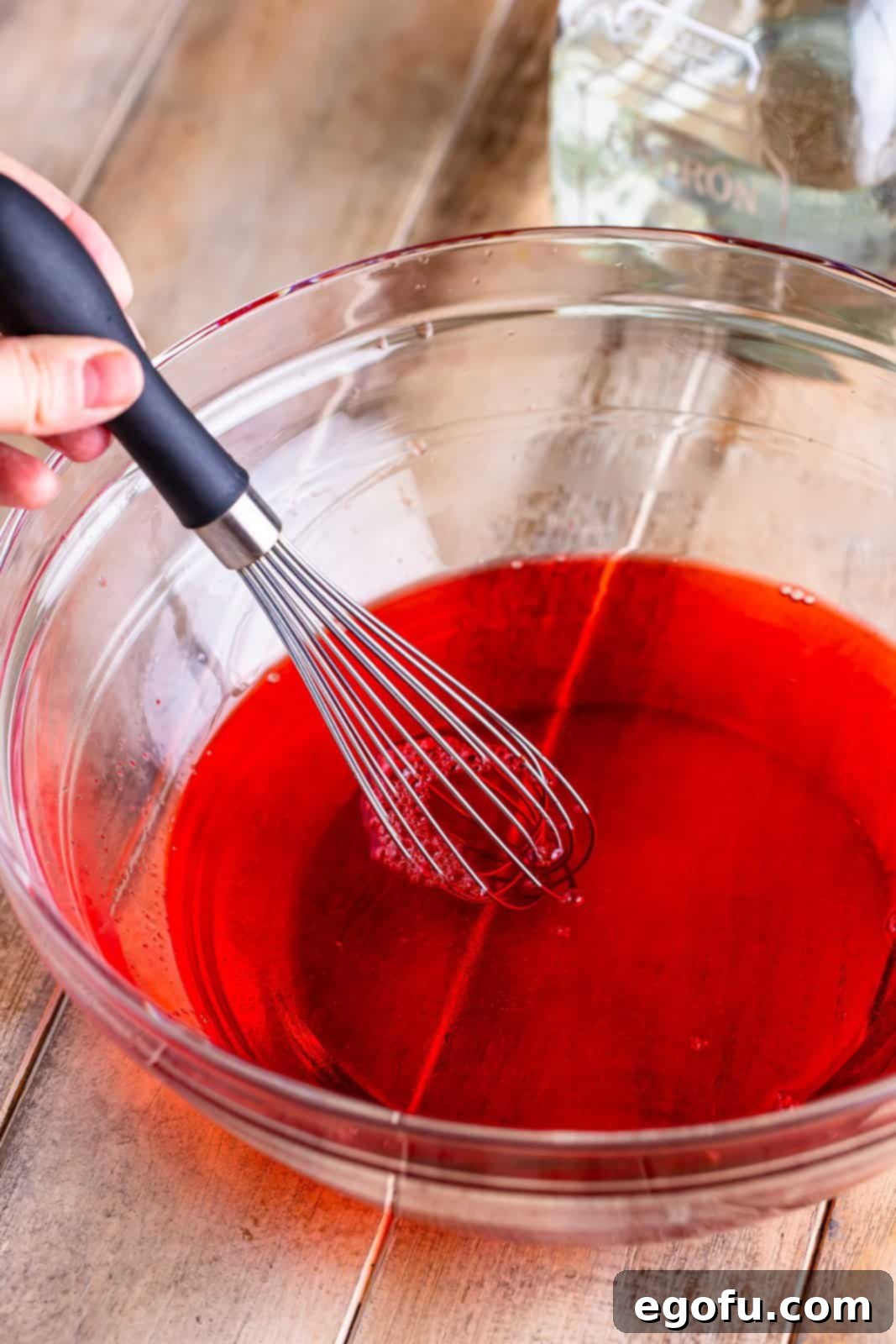 A mixing bowl with strawberry jello.