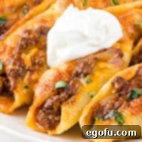 Stuffed shells with taco flavors, topped with sour cream and cilantro, presented as a recipe thumbnail.