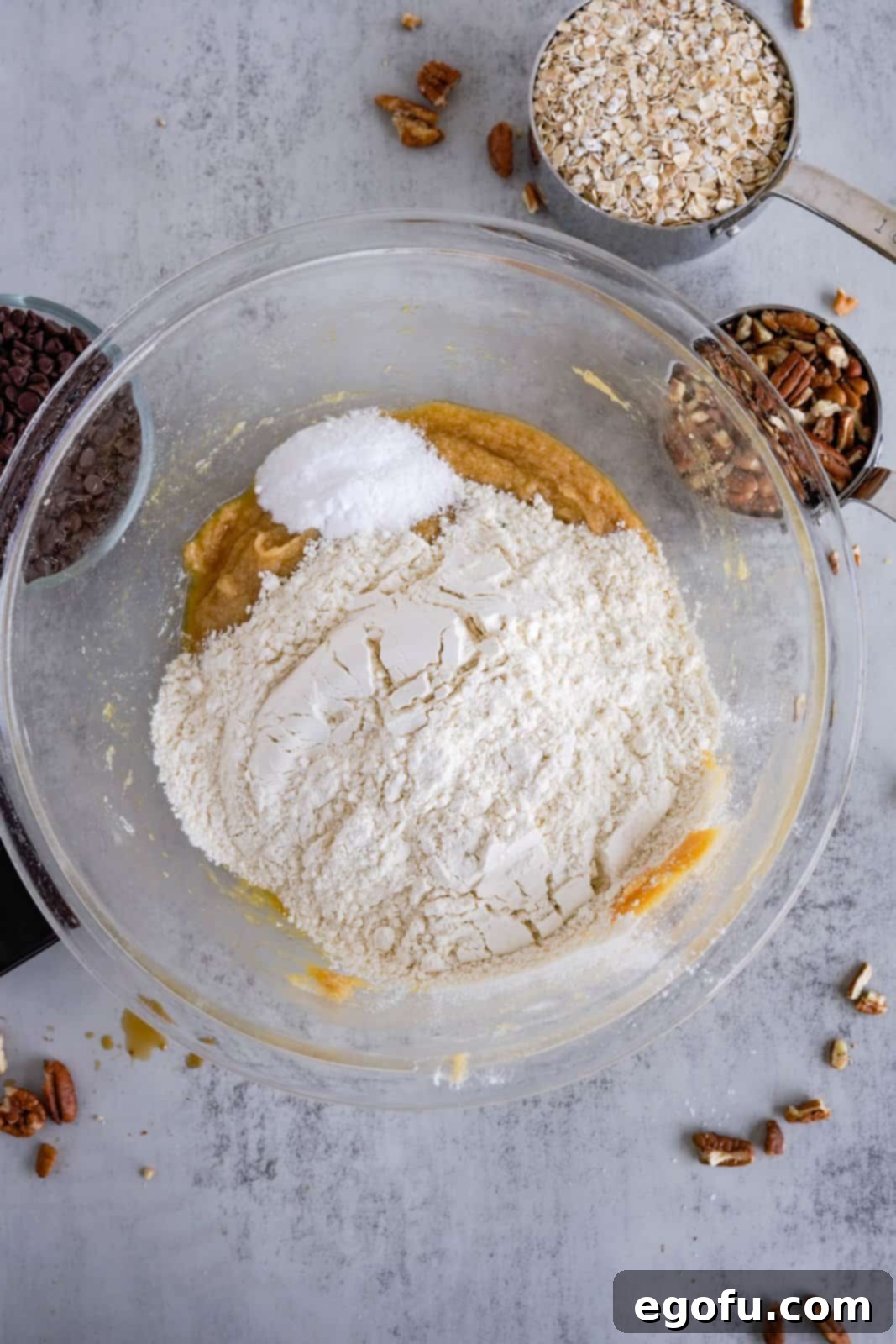 Oatmeal Chocolate Chip Delights 7 Mixing dry ingredients (flour, baking soda, salt) into wet cookie dough mixture carefully to avoid overmixing.