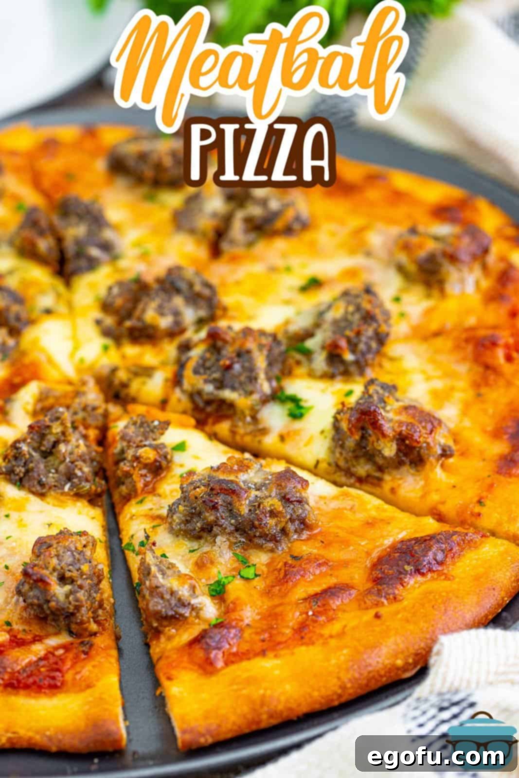 Close to a meatball pizza so you can see the meat and cheese melting together.