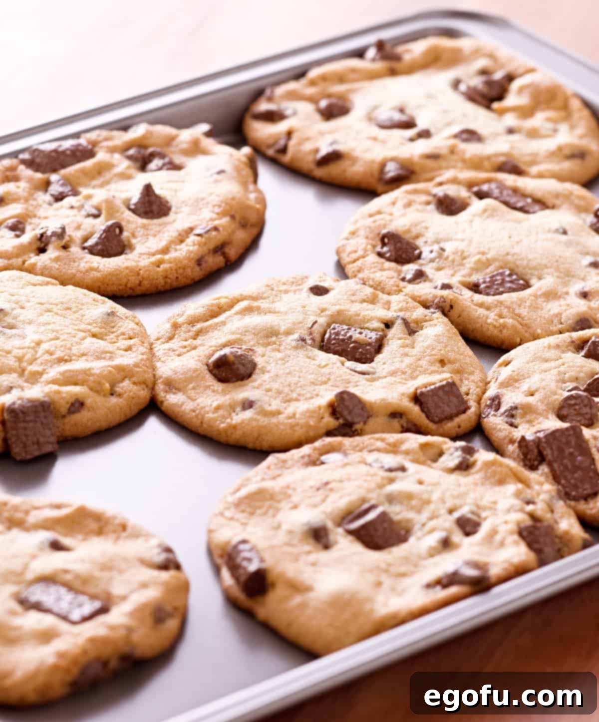 Freshly baked cookies, golden brown and perfectly cooked, cooling on a rack right out of the oven.