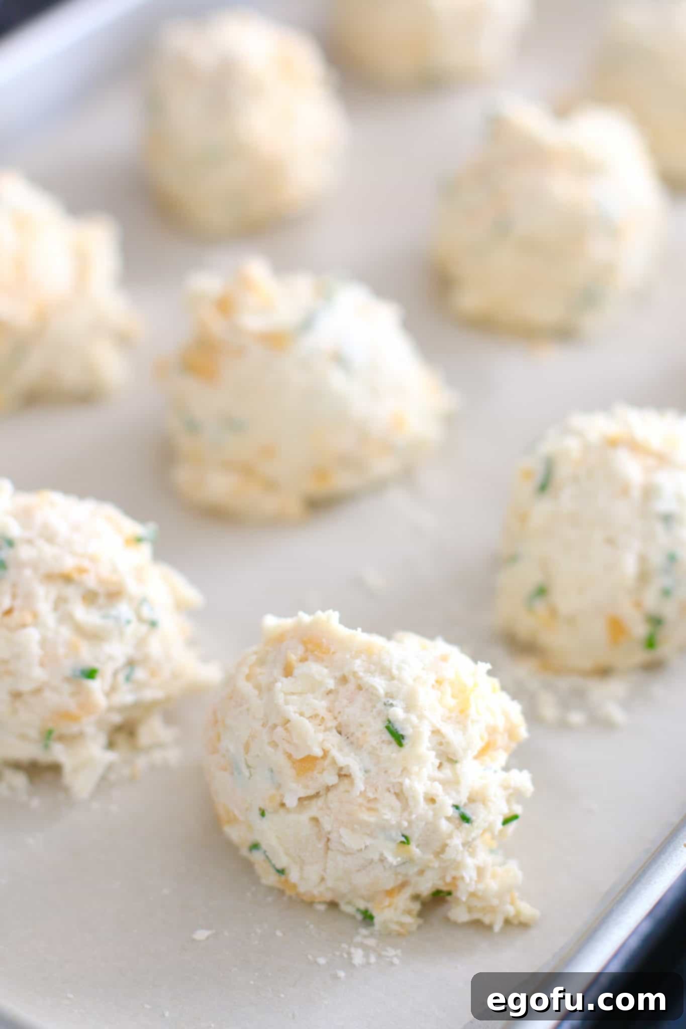 Easy cheddar chive drop biscuit batter in a bowl, showing the perfect consistency before baking.