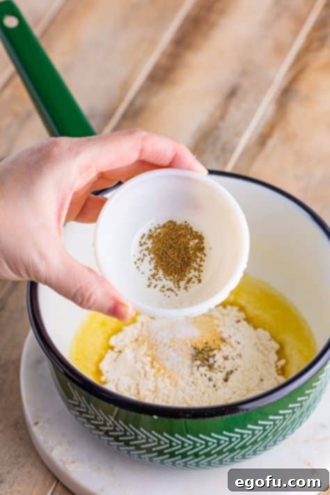 flour and spices added to melted butter in a pot.