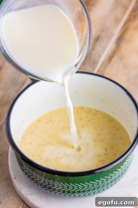 milk being poured into sauce pan.
