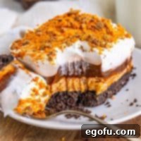 Golden Butterfinger Dream 16 A plate with a slice of Butterfinger Lush and a fork with a bite missing, ready to be enjoyed.