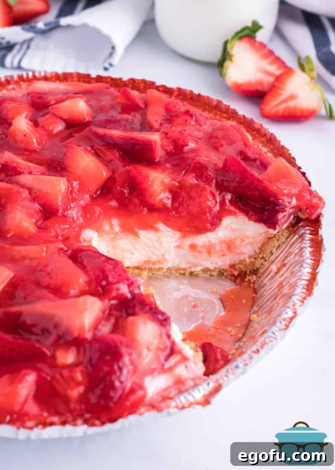 A whole Strawberry Cream Cheese Pie with a slice removed, showing its delicious interior.