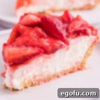Close up looking at a piece of Strawberry Cream Cheese pie with fresh strawberries on top.