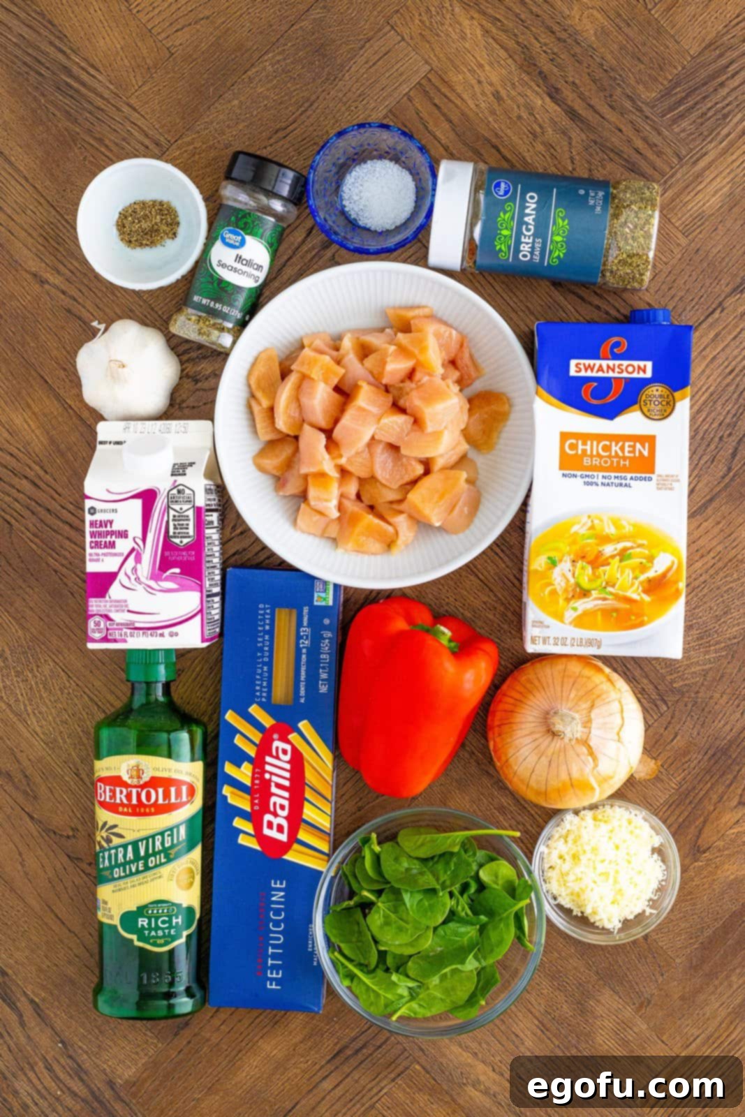Chicken breasts, chicken broth, spinach, olive oil, salt and pepper, onion, red bell pepper, garlic, Italian seasoning, dried oregano, fettuccini, heavy cream, and grated parmesan cheese.