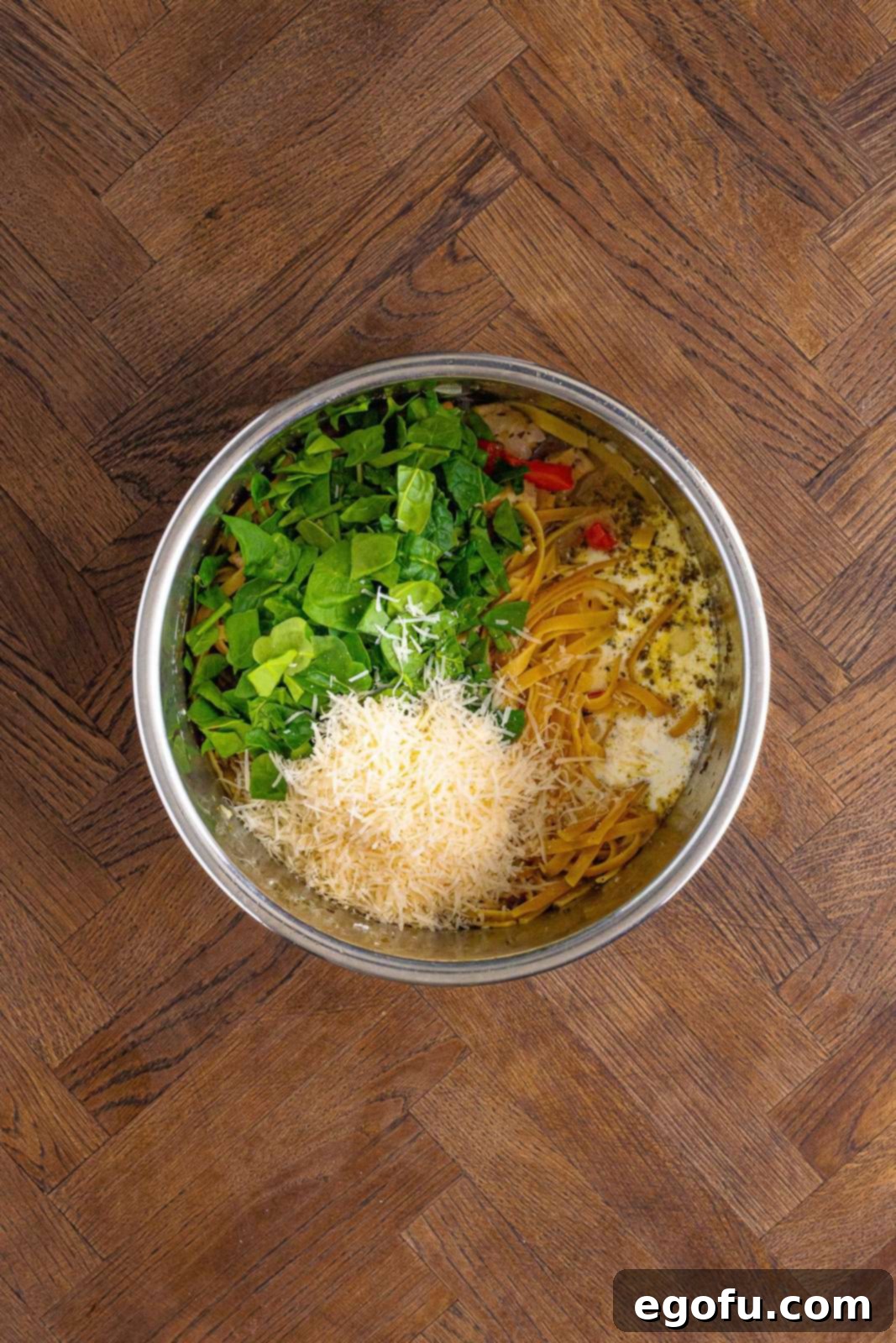 Heavy cream, spinach, and parmesan cheese on top of everything else for the Creamy Garlic Chicken Pasta in the Instant Pot.