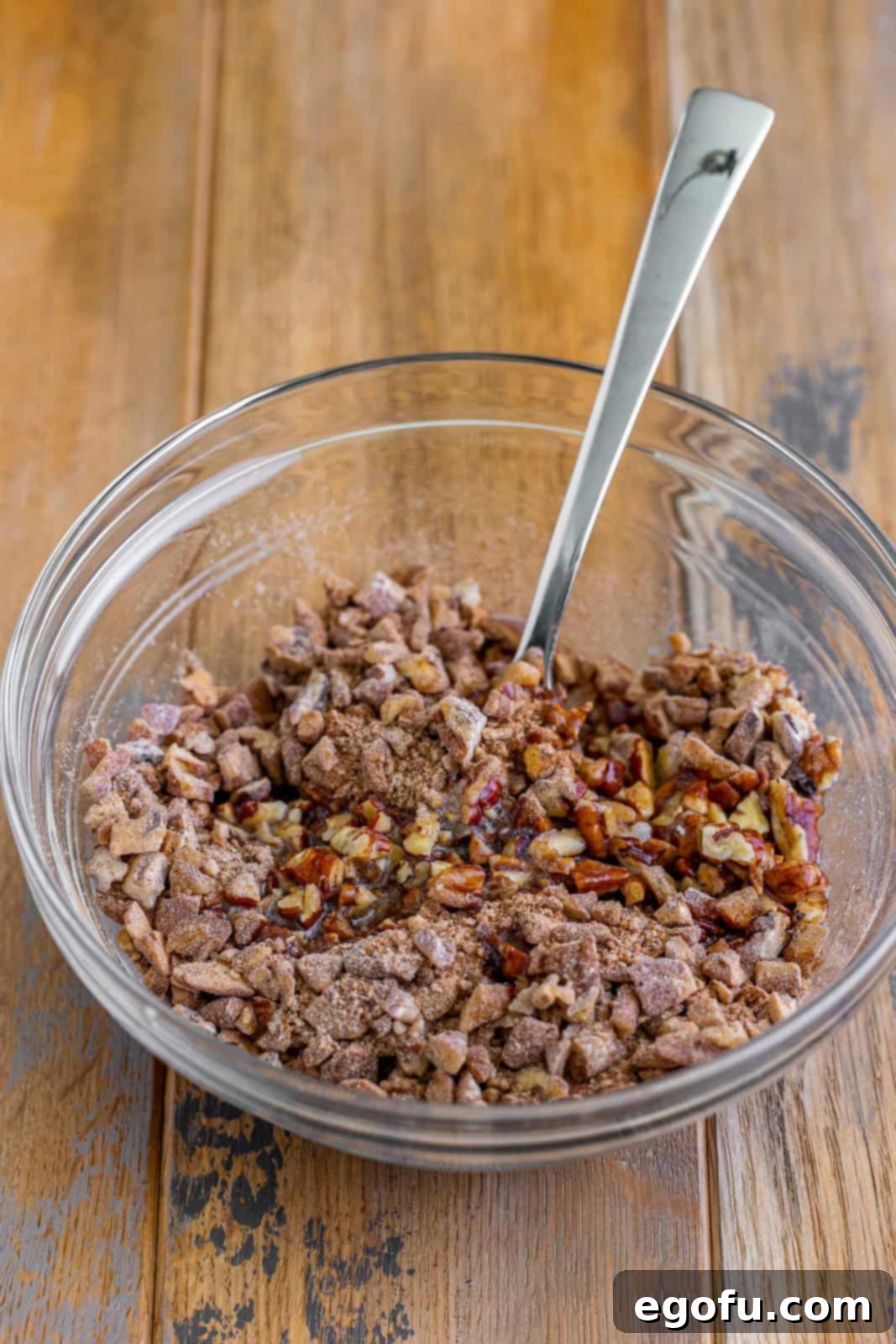 A small mixing bowl with pecans, brown sugar, and cinnamon.