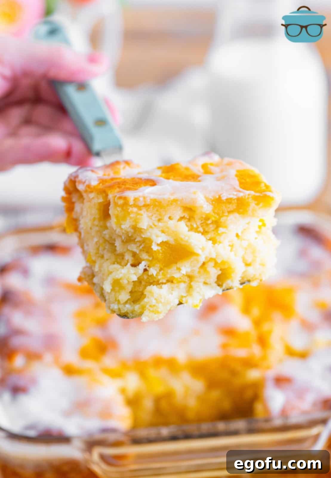 Sun-Kissed Peach Butter Swim Biscuits 2 A serving utensil holding a Peach Butter Swim Biscuit, showcasing its soft interior and golden crust.