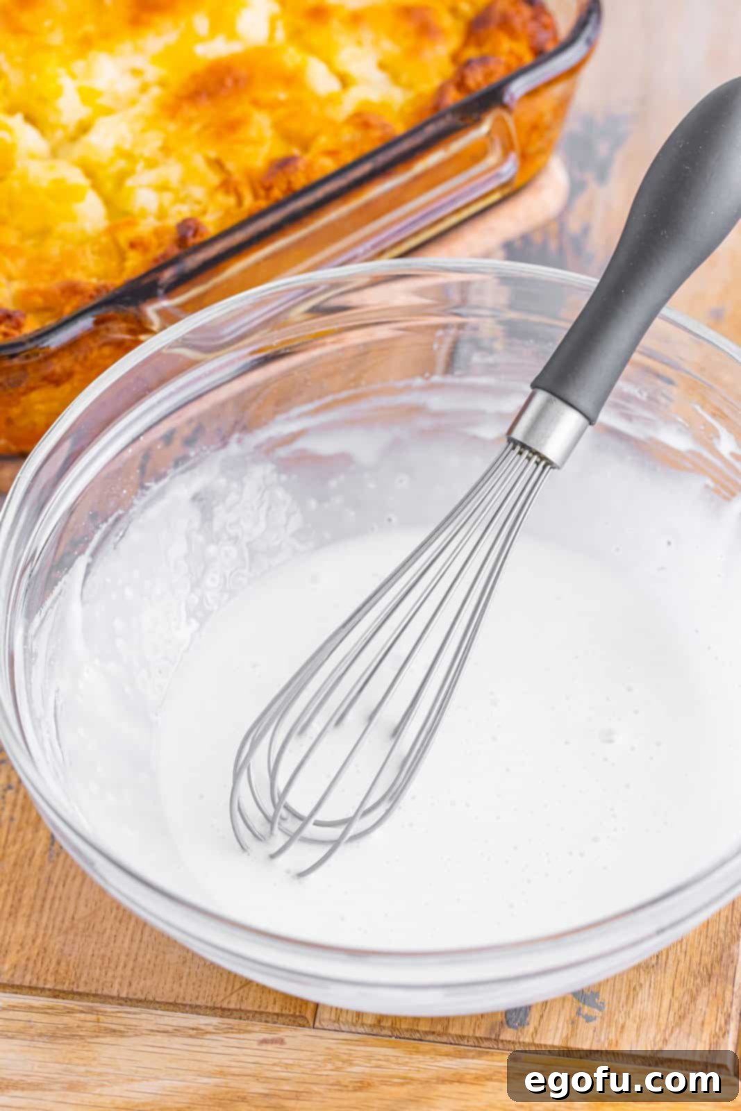 Sun-Kissed Peach Butter Swim Biscuits 12 A bowl of powdered sugar, milk, and vanilla extract being whisked together to form the biscuit icing.