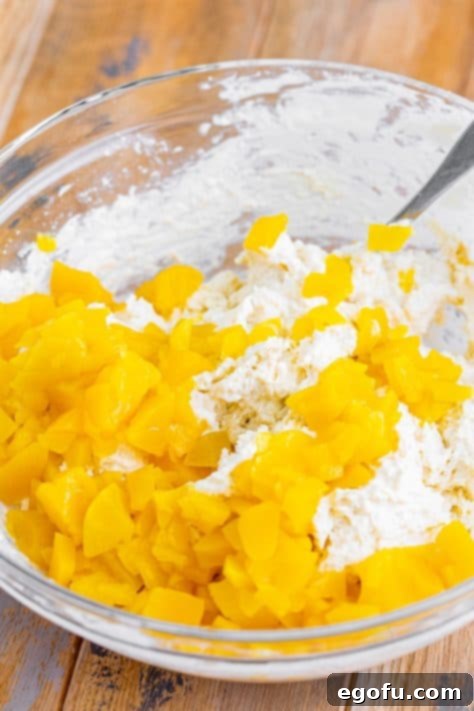 Sun-Kissed Peach Butter Swim Biscuits 18 A mixing bowl with flour, sugar , heavy cream, vanilla, peach chunks, and baking powder.