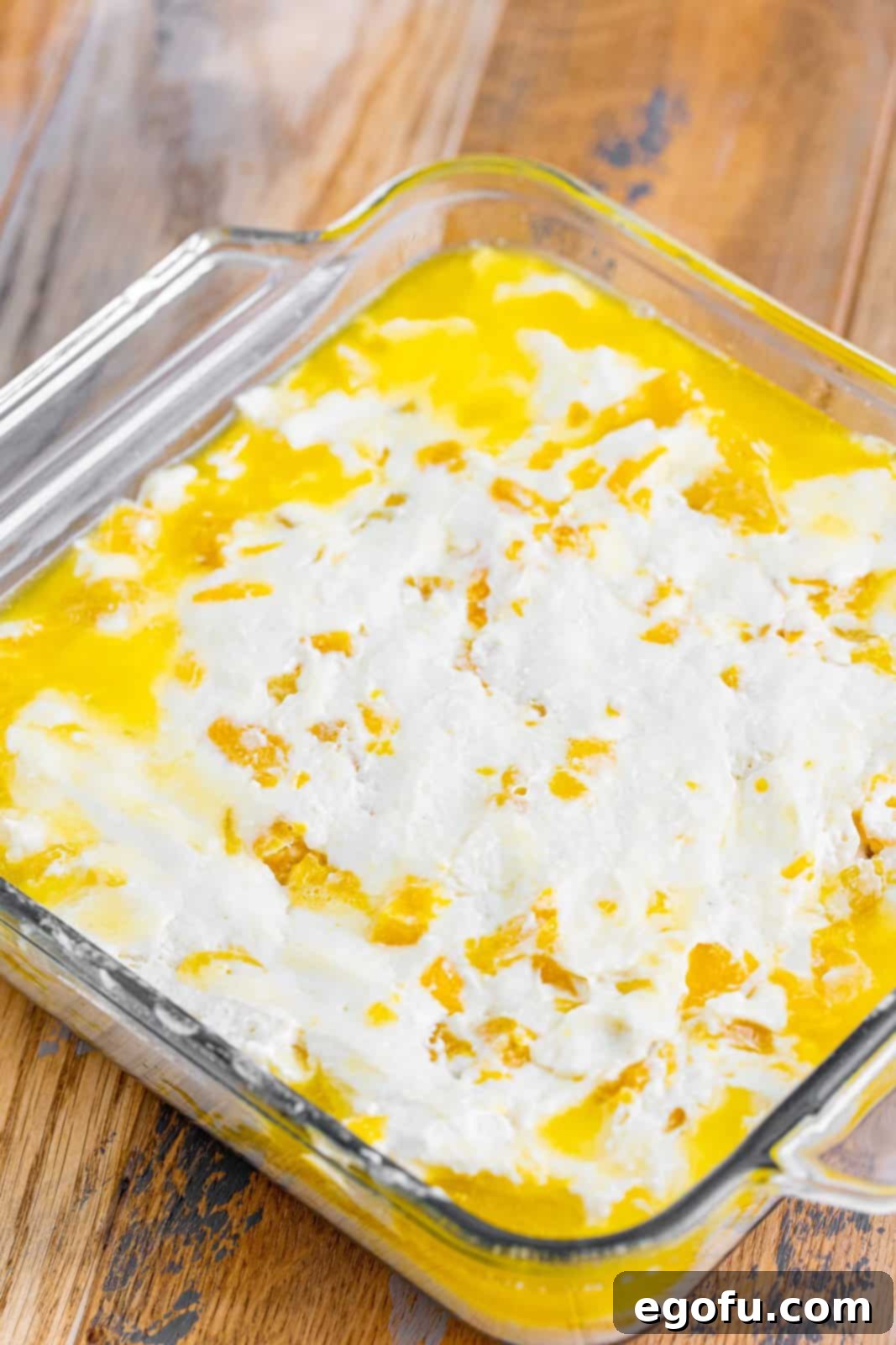 Sun-Kissed Peach Butter Swim Biscuits 9 Biscuit dough carefully spread over melted butter in a baking dish, before baking.