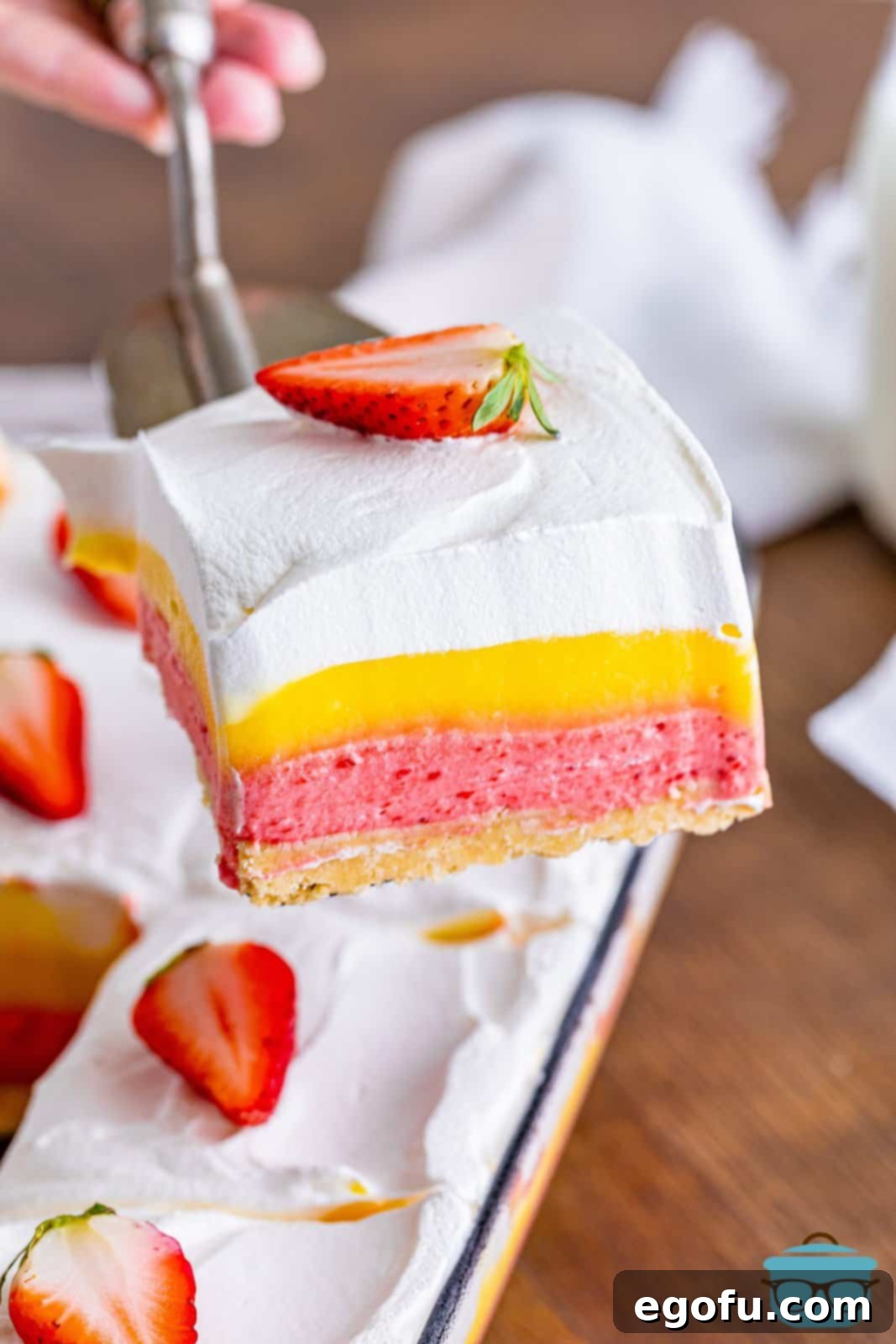 Layered Strawberry Bliss 14 A serving utensil holding a perfect slice of Strawberry Lasagna, ready to be enjoyed.