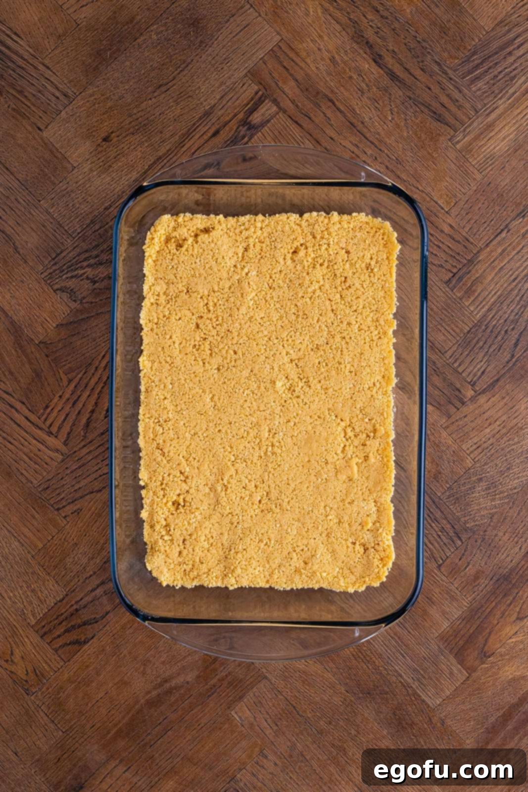 Layered Strawberry Bliss 7 A golden Oreo crumb crust pressed firmly into a 9x13-inch baking dish.