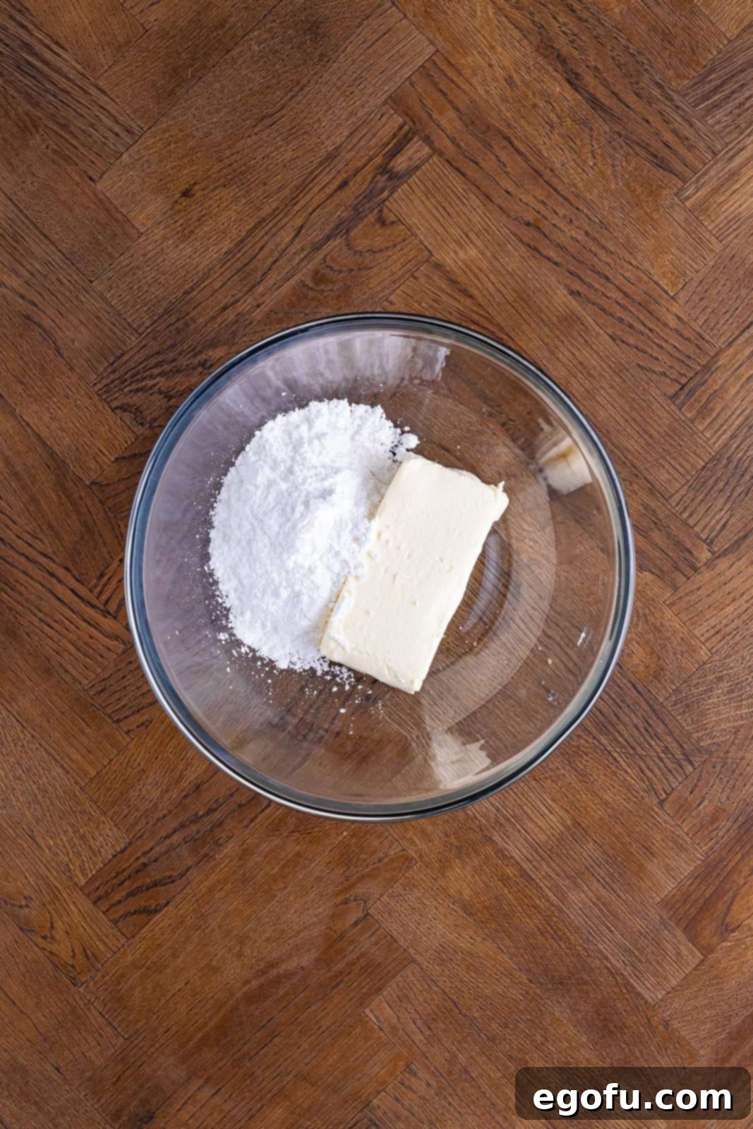 Layered Strawberry Bliss 9 Powdered sugar and softened cream cheese being whipped in a mixing bowl.