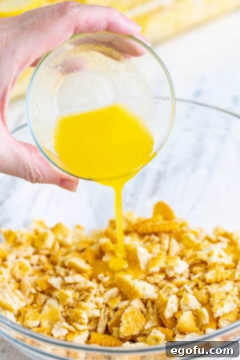 Melted butter poured over crushed crackers, ready to be mixed.