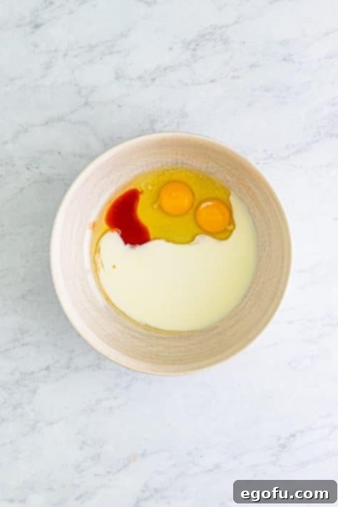 Golden Crispy Catfish 15 eggs, hot sauce and buttermilk in a bowl.