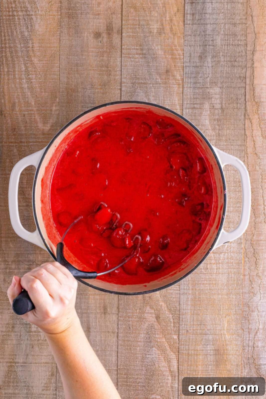 From Garden or Freezer: Homemade Strawberry Jam 4 A pot of strawberry jam with a potato masher.