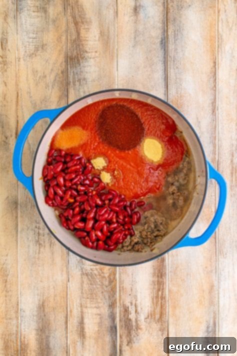 All chili ingredients mixed in a Dutch oven before simmering.