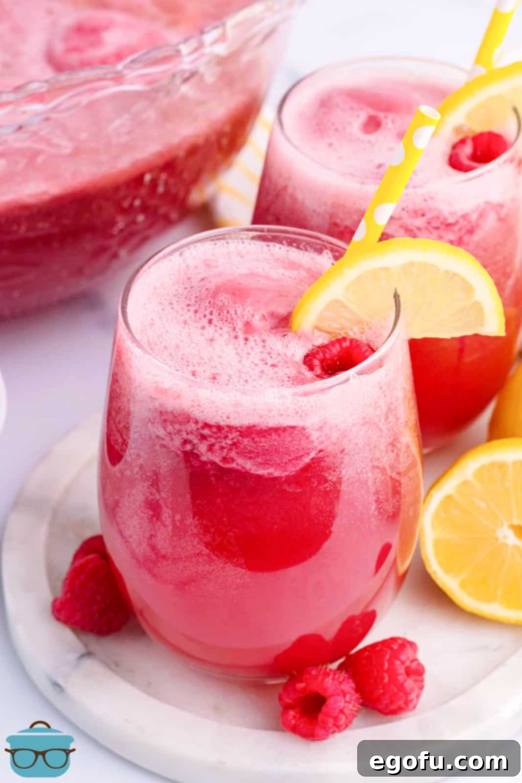 Stork's Sipper 2 A glass of baby shower punch with a lemon slice and straw, perfect for a joyful celebration.