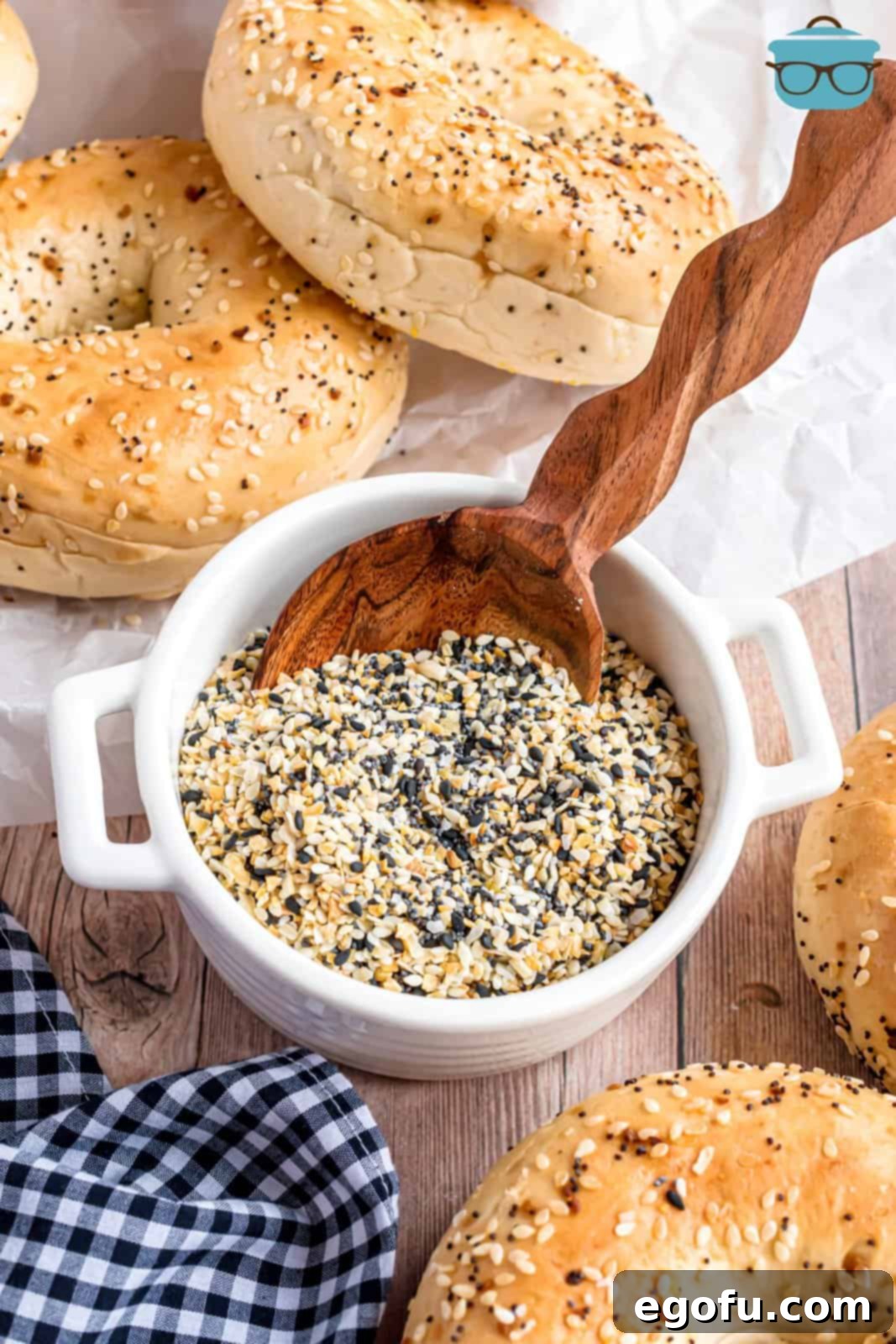 A bowl of Everything But the Bagel seasoning and a few bagels around it.