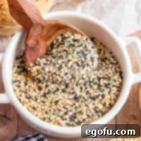 Closely looking down on a bowl of Everything But the Bagel Seasoning with a spoon holding some.