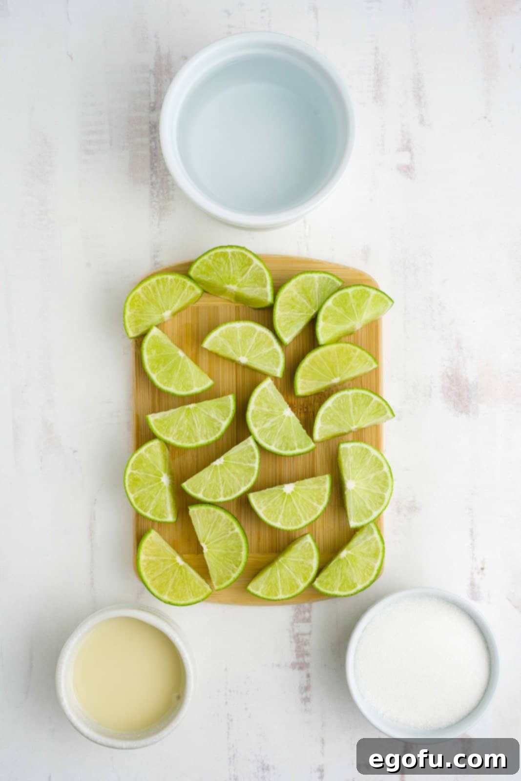Brazilian Lemon Dream 4 Fresh lime wedges, granulated sugar, cold water, and sweetened condensed milk arranged as ingredients for Brazilian Lemonade.
