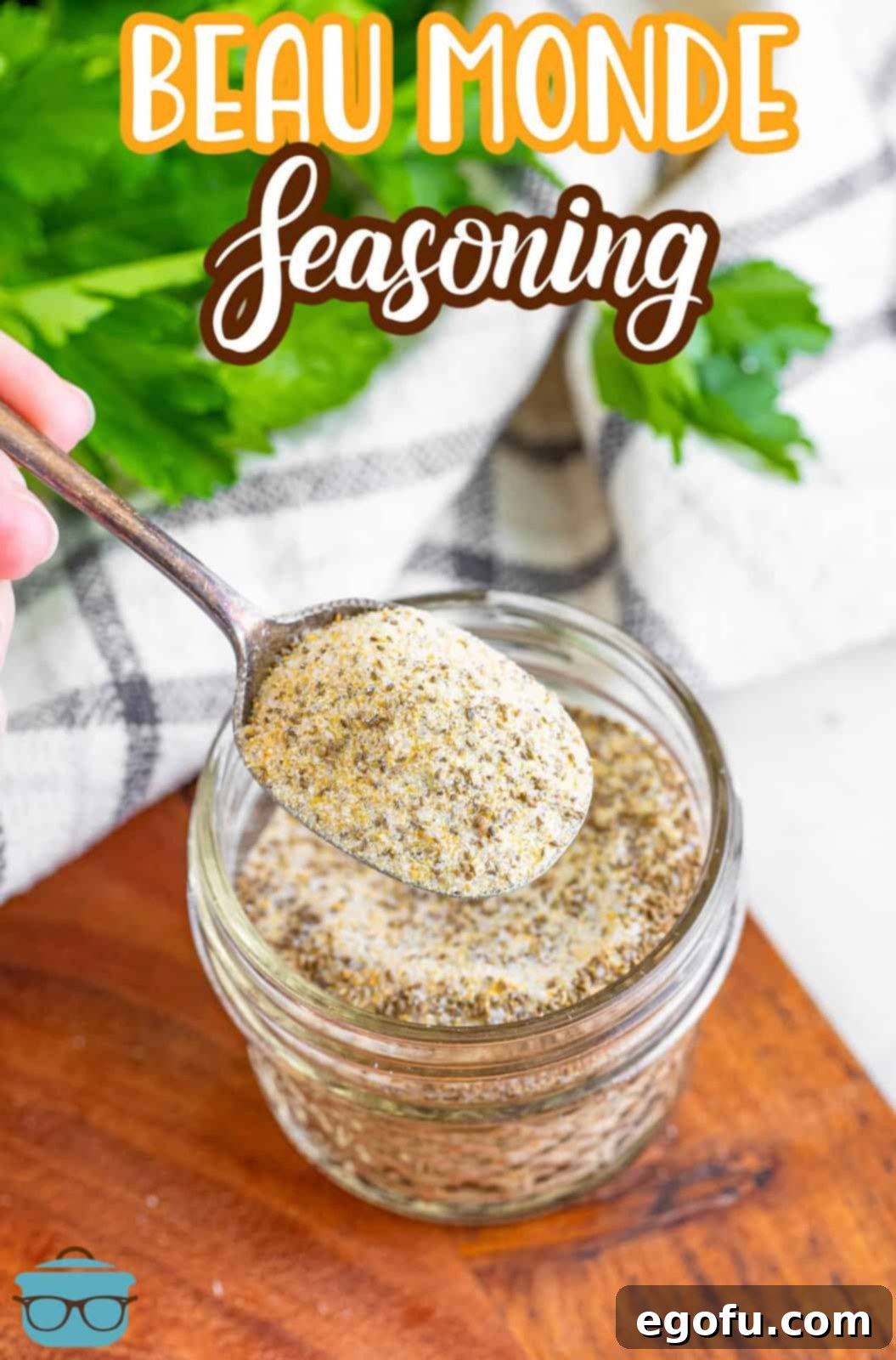 A spoon holding some Beau Monde® Seasoning above a jar of it, showcasing its fine texture.