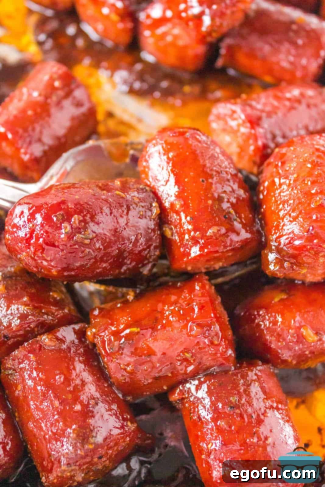 Close up looking at a bunch of hot dog burnt ends with a glossy, caramelized sauce.